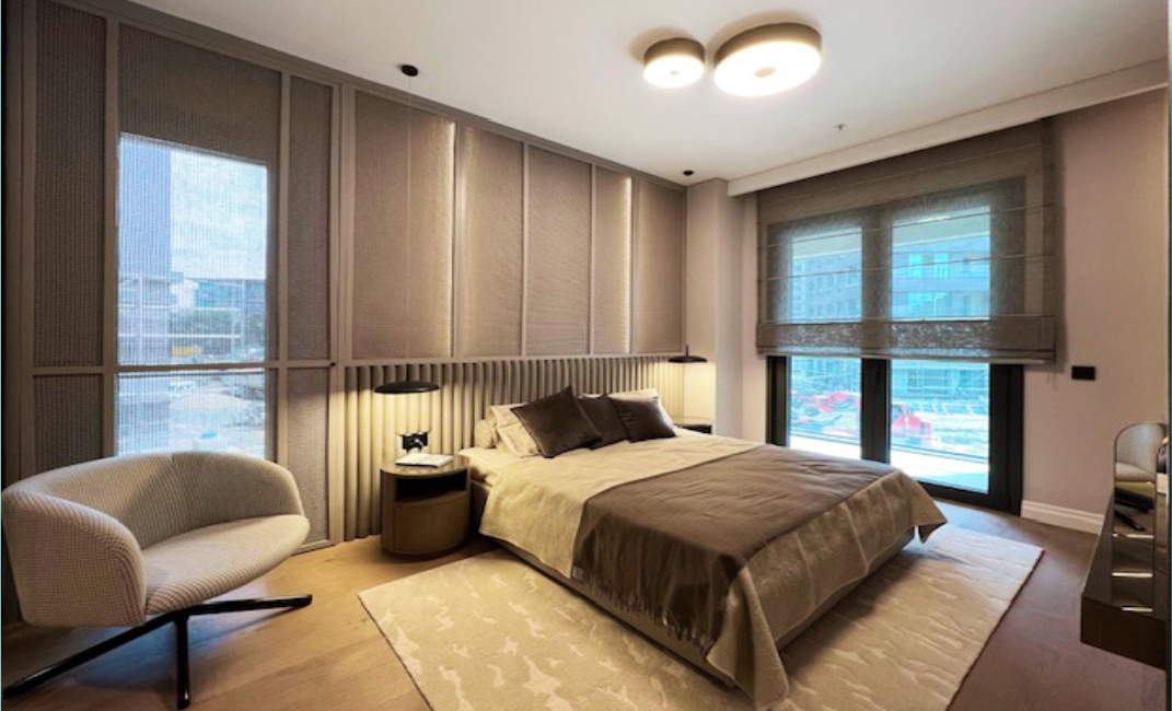 دکوراسیون داخلی اتاق نشیمن مدرن با پنجره‌های قدی و دیوار تلویزیون سنگی